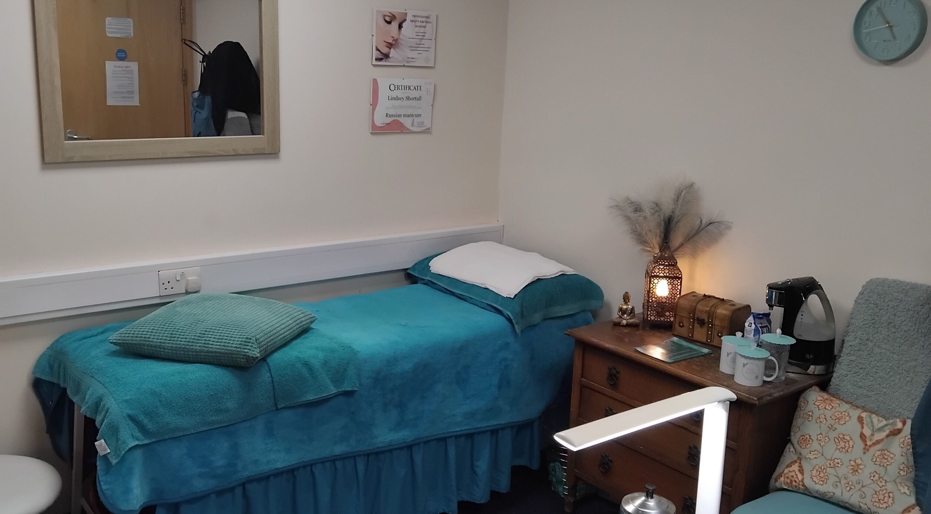Cozy massage room at The Nook, Ellesmere Port, England, GB with blue decor and wooden furniture.