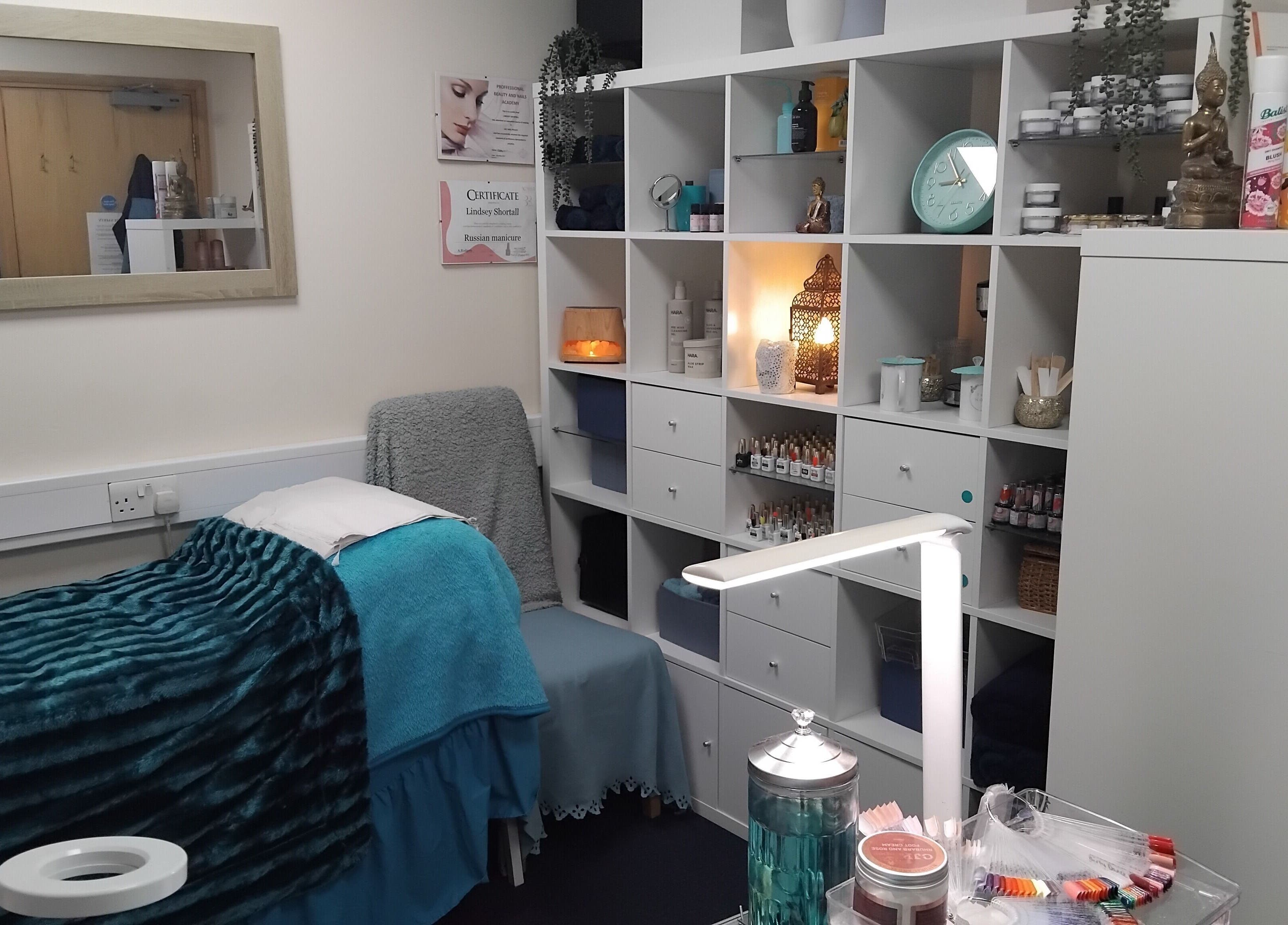 A cozy treatment room at The Nook, Ellesmere Port, England, GB with a massage bed and elegant decor.