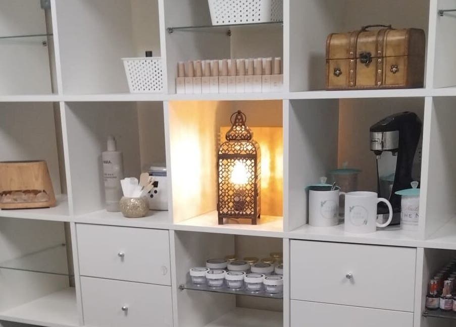 Cozy shelving at The Nook, Ellesmere Port, England, GB featuring a warm lantern and organized beauty products.