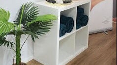 Elegant spa corner at Beauty by Manola, Bayview, Northern Territory, AU, featuring green plants and rolled towels.