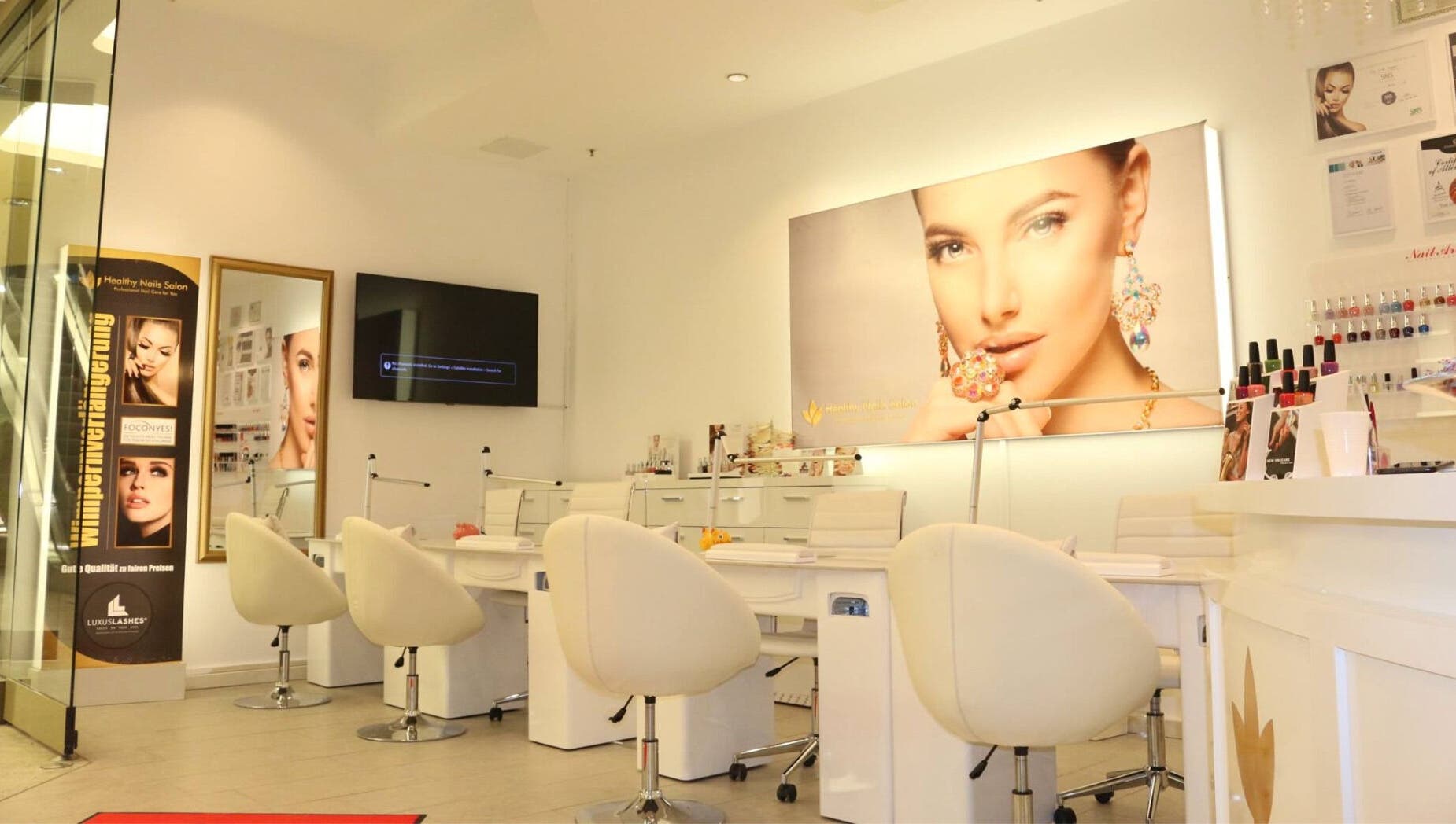 Innenansicht von Healthy Nails Salon in Kiel, Schleswig-Holstein, DE mit modernen weißen Sitzen und Wanddekoren.