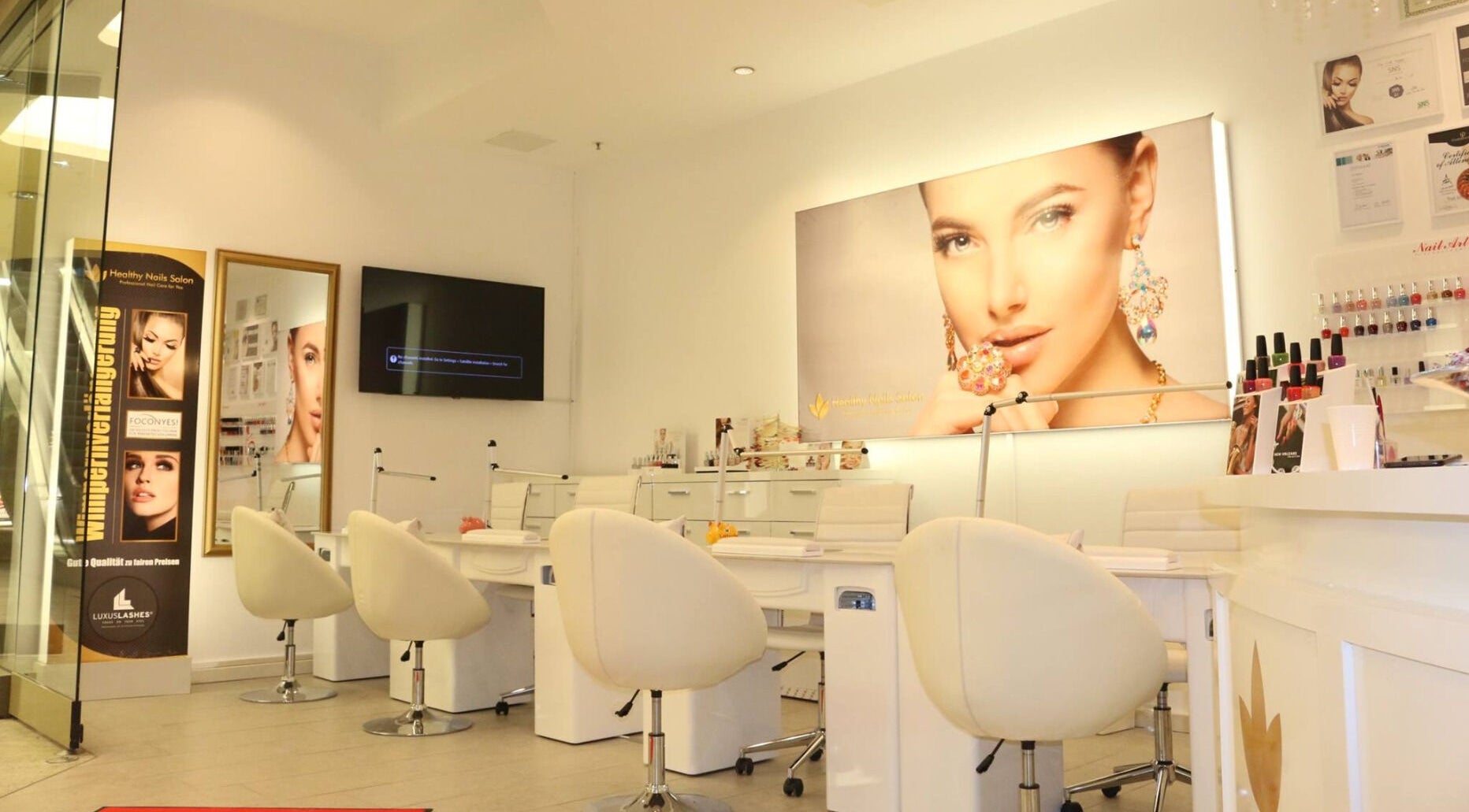 Innenansicht von Healthy Nails Salon in Kiel, Schleswig-Holstein, DE mit modernen weißen Sitzen und Wanddekoren.