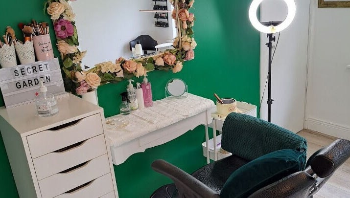 Chic makeup station at Secret Garden Makeup & Beauty, Enniscorthy, IE with floral mirror and green accents.