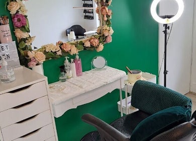 Chic makeup station at Secret Garden Makeup & Beauty, Enniscorthy, IE with floral mirror and green accents.