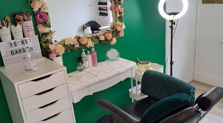Chic makeup station at Secret Garden Makeup & Beauty, Enniscorthy, IE with floral mirror and green accents.