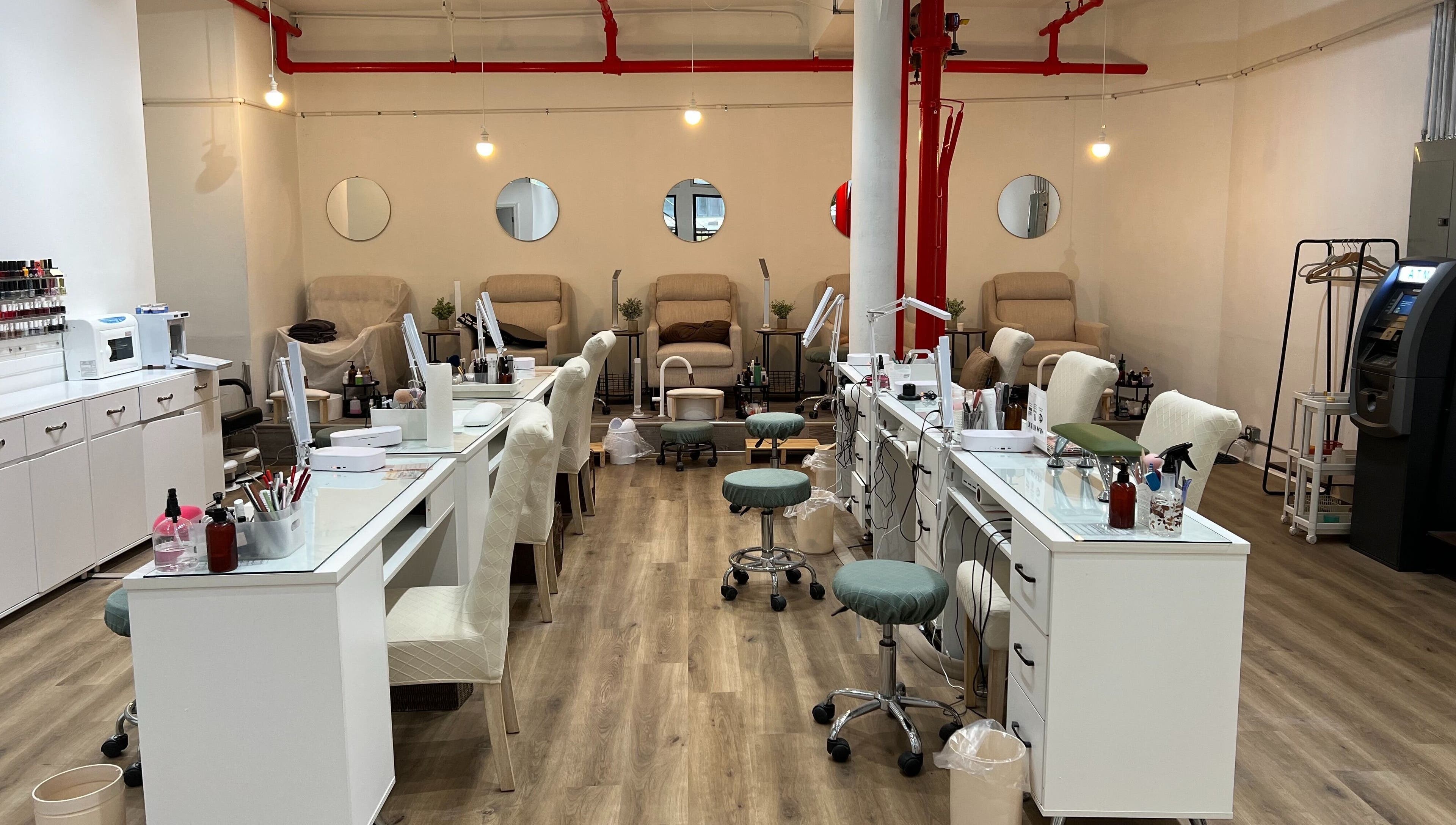 Chic interior of M&M Studio NYC nail studio, New York, New York, US with modern nail stations and cozy seating.