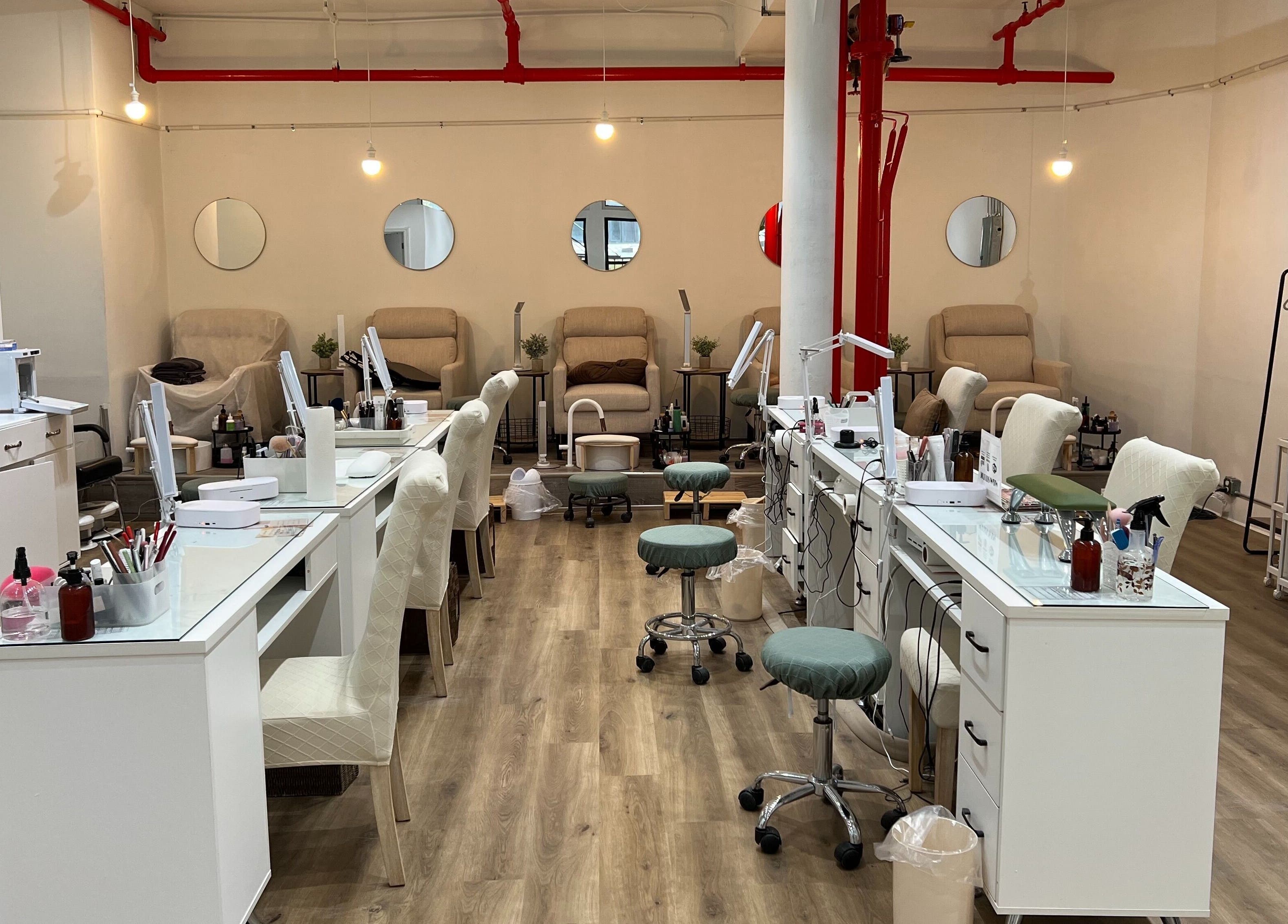 Chic interior of M&M Studio NYC nail studio, New York, New York, US with modern nail stations and cozy seating.