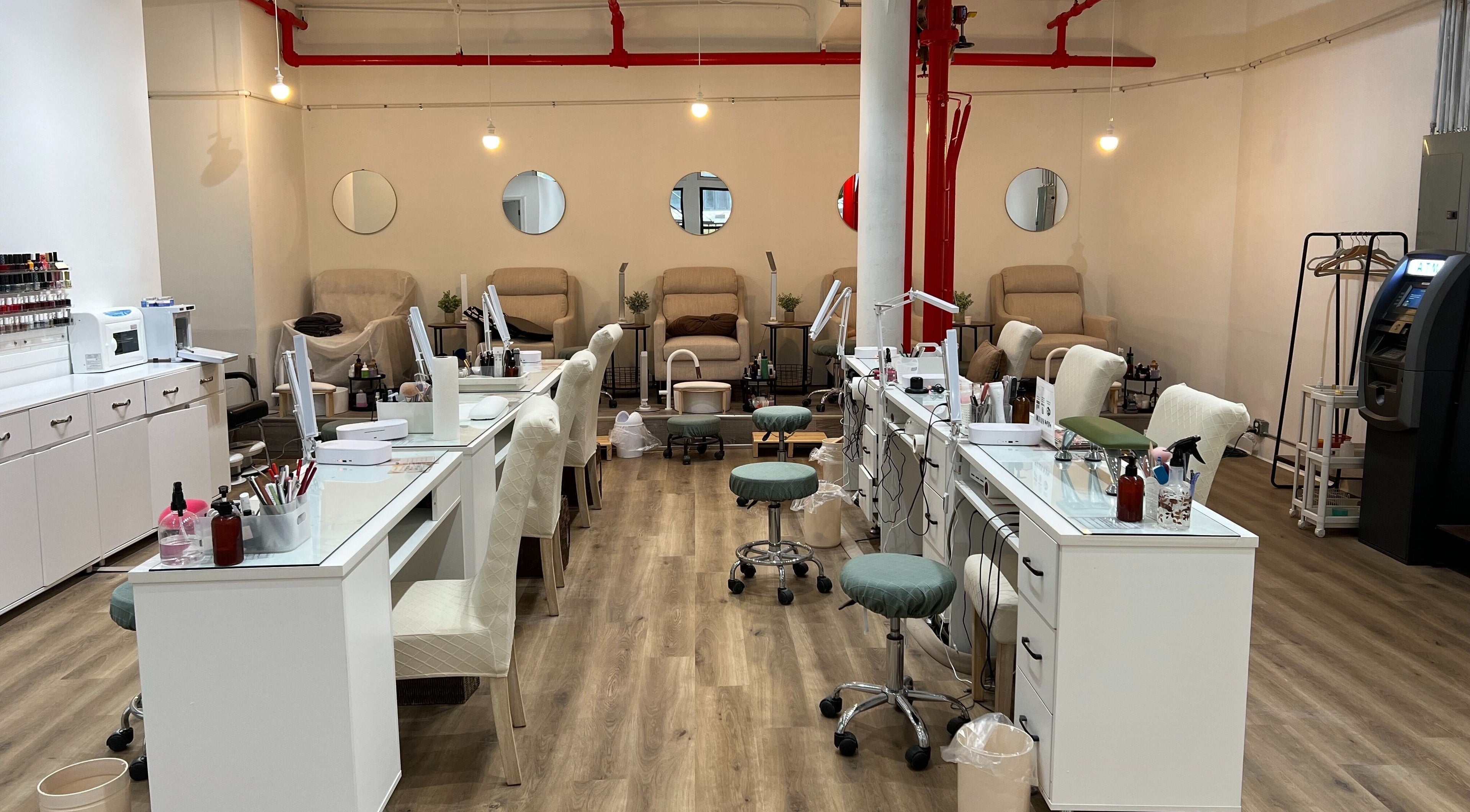 Chic interior of M&M Studio NYC nail studio, New York, New York, US with modern nail stations and cozy seating.