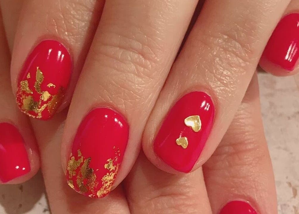 Luxurious red nails with gold accents at M&M Studio NYC, New York, New York, US.