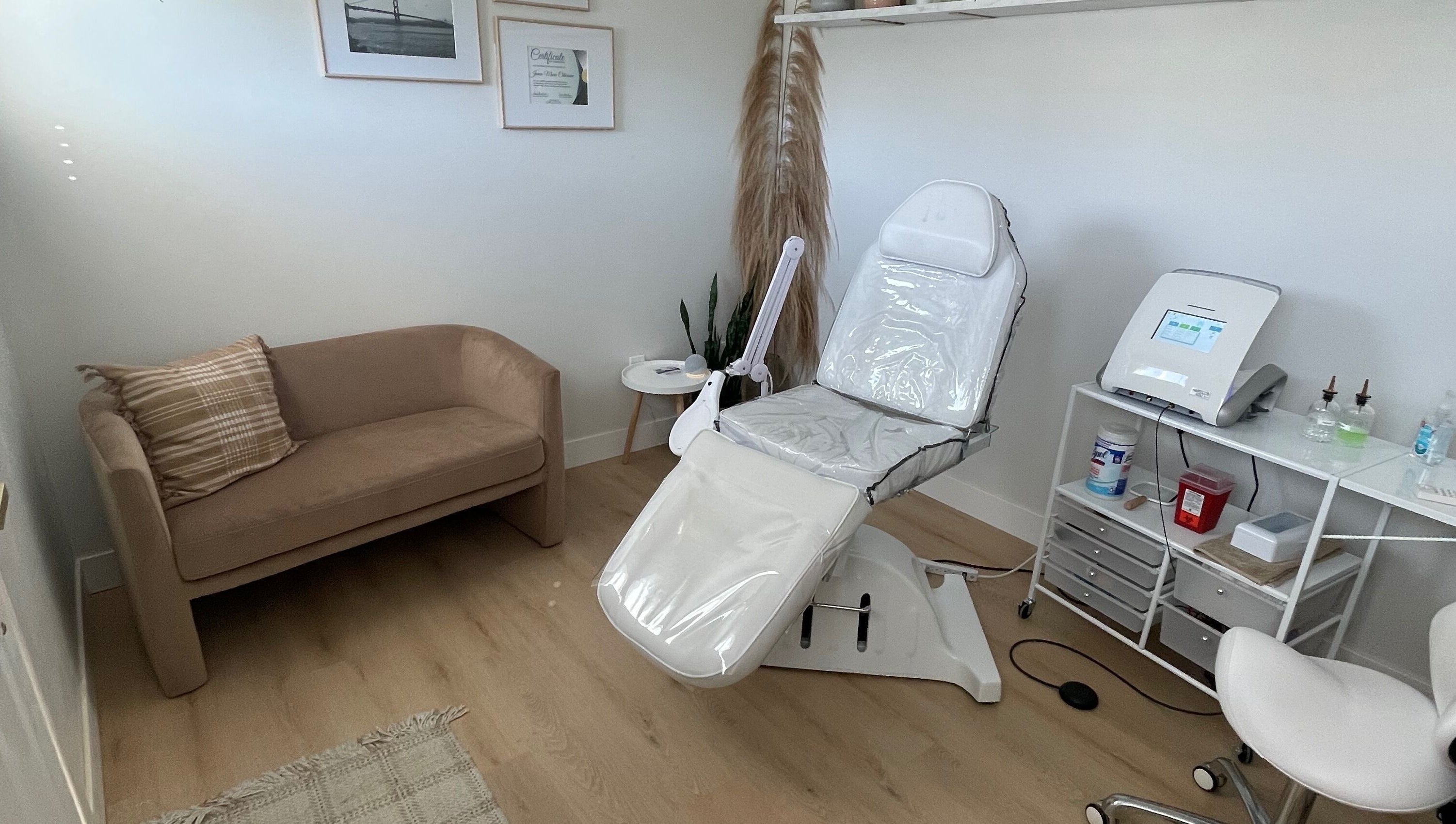Calming treatment room at Silk Electrolysis in Herriman, Utah, US with a chair, sofa, and equipment.