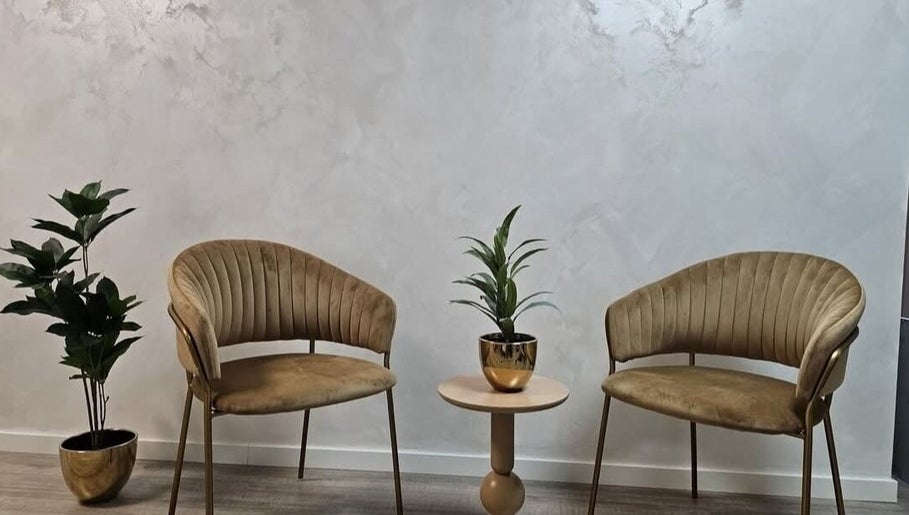 Eleganckie fotele w salonie Primrose Beauty Salon, Helden, Limburg, NL z roślinami w tle.