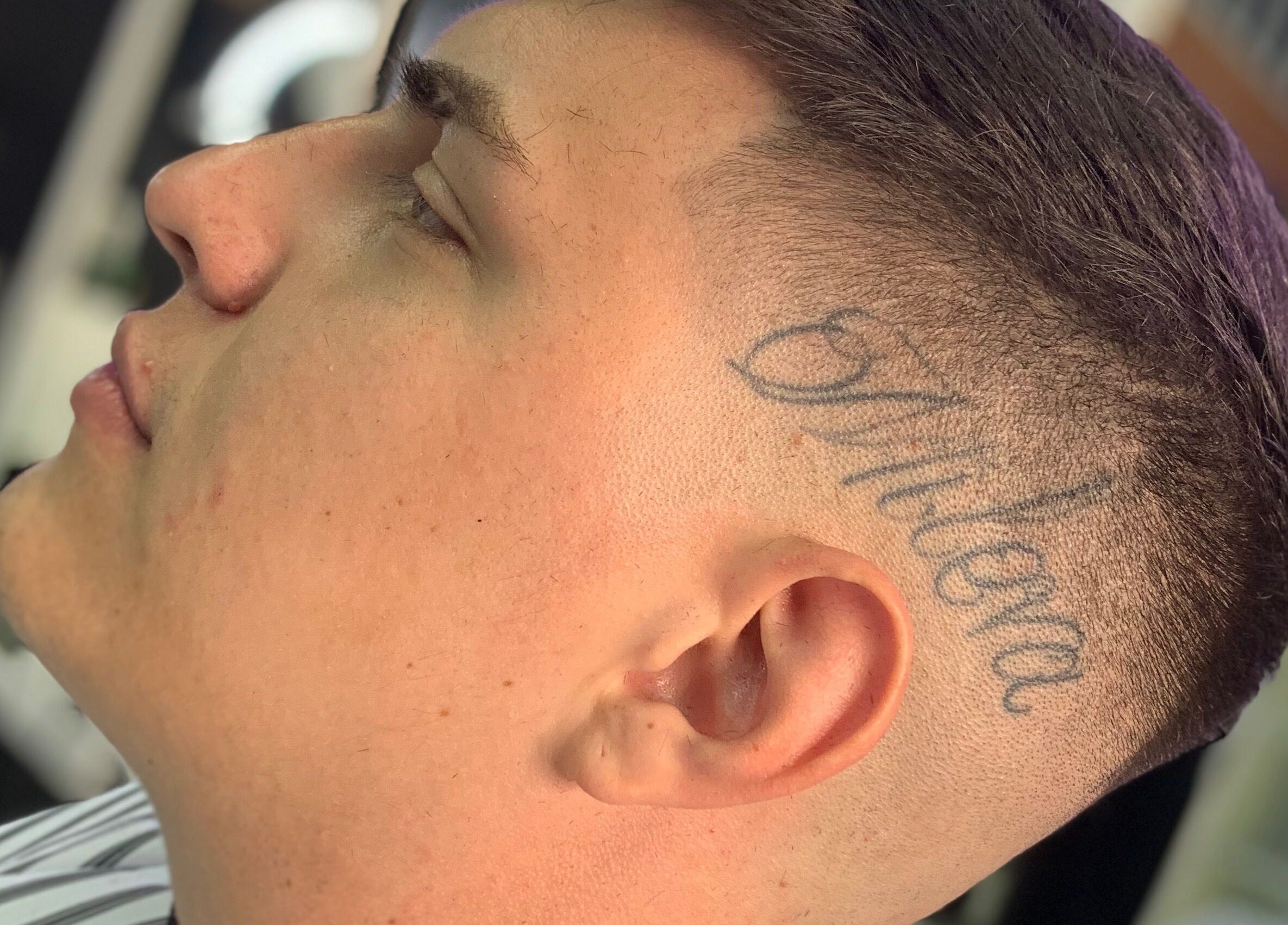 Tatuaje único y corte de cabello moderno en MALDITO SANTO, Victoria, Provincia De Buenos Aires, AR.