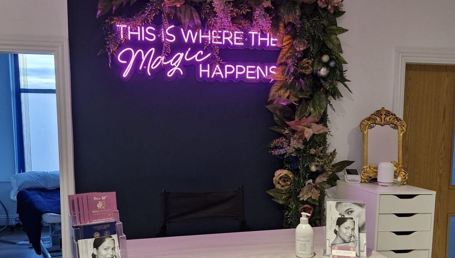Reception at Wild Jasmine Retreat, Ramsbottom with floral decor and neon sign 'This is where the magic happens'.