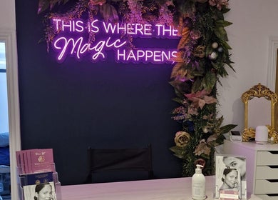 Reception at Wild Jasmine Retreat, Ramsbottom with floral decor and neon sign 'This is where the magic happens'.