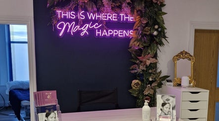 Reception at Wild Jasmine Retreat, Ramsbottom with floral decor and neon sign 'This is where the magic happens'.