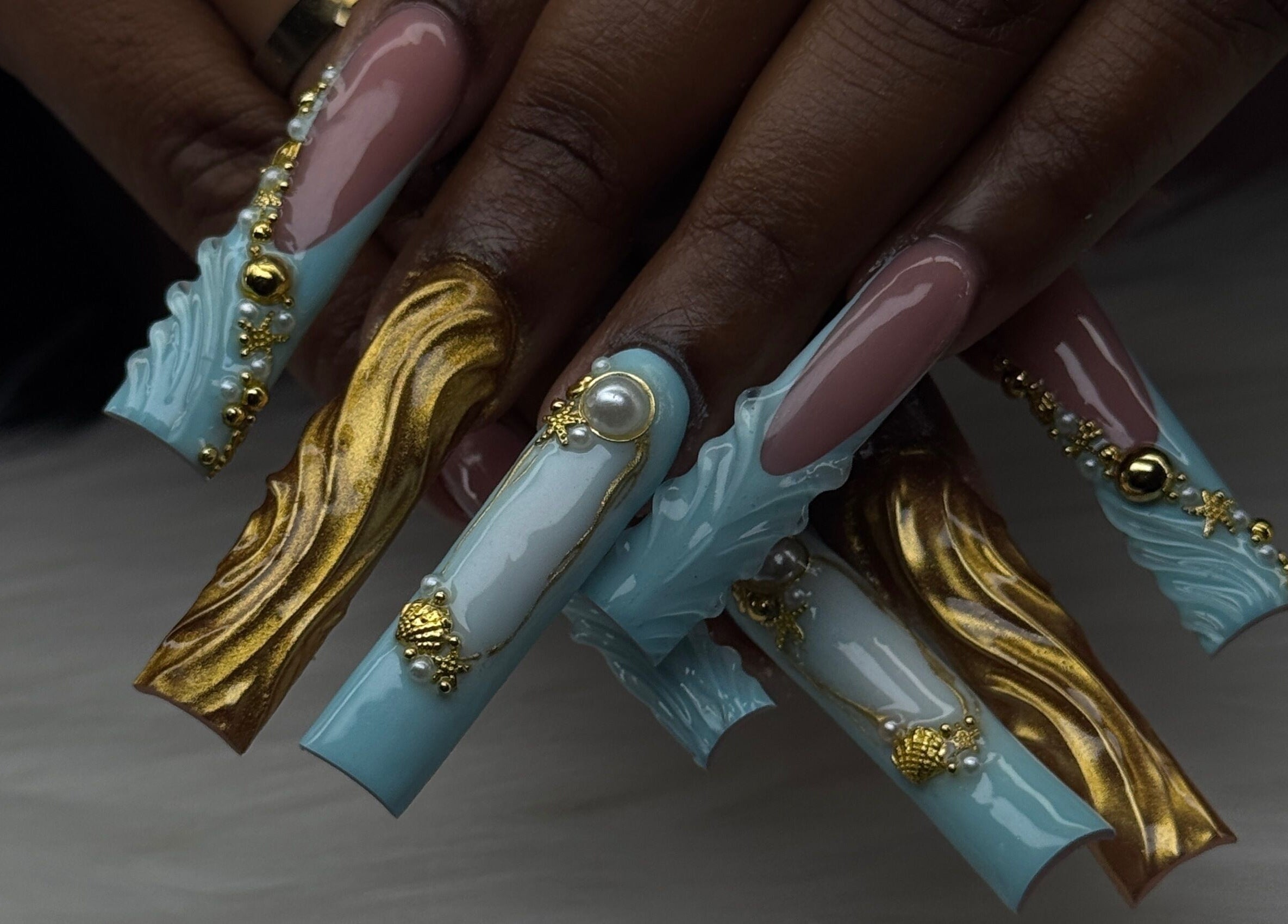 Intricate nail art with jewels and gold at Luxura.Beauty, Willemstad, CW. Luxurious nail design showcase.