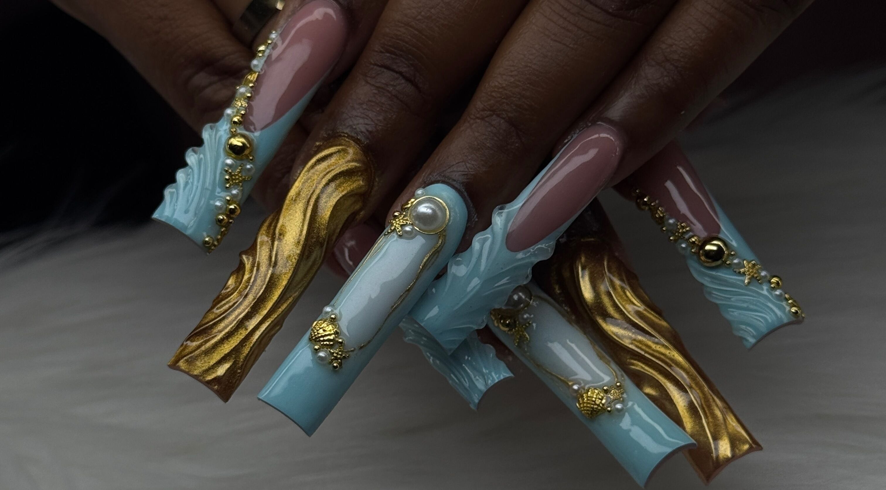 Intricate nail art with jewels and gold at Luxura.Beauty, Willemstad, CW. Luxurious nail design showcase.