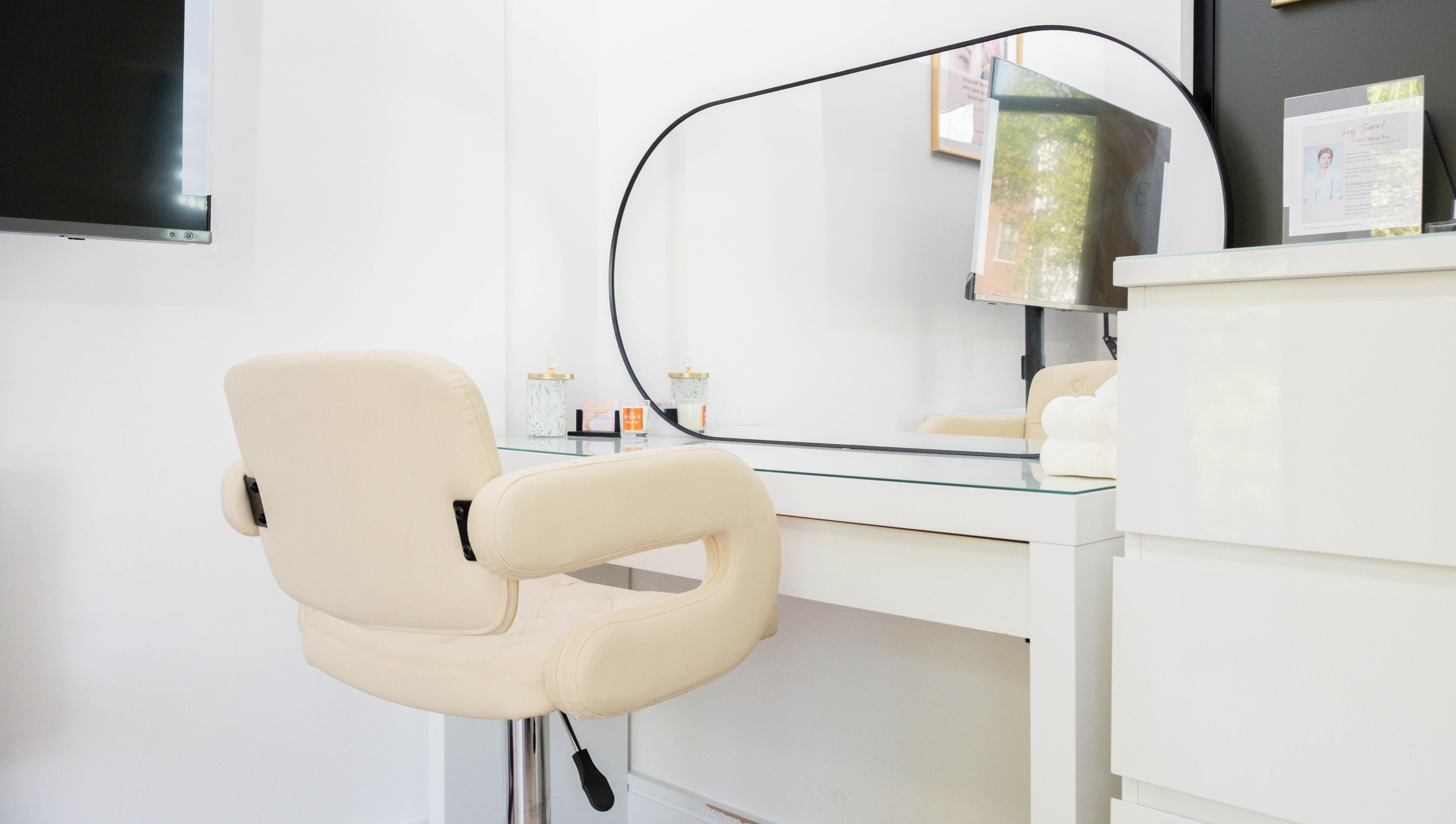 Modern vanity setup at Unique Brow London, featuring a cream chair and mirror. London, England, GB.