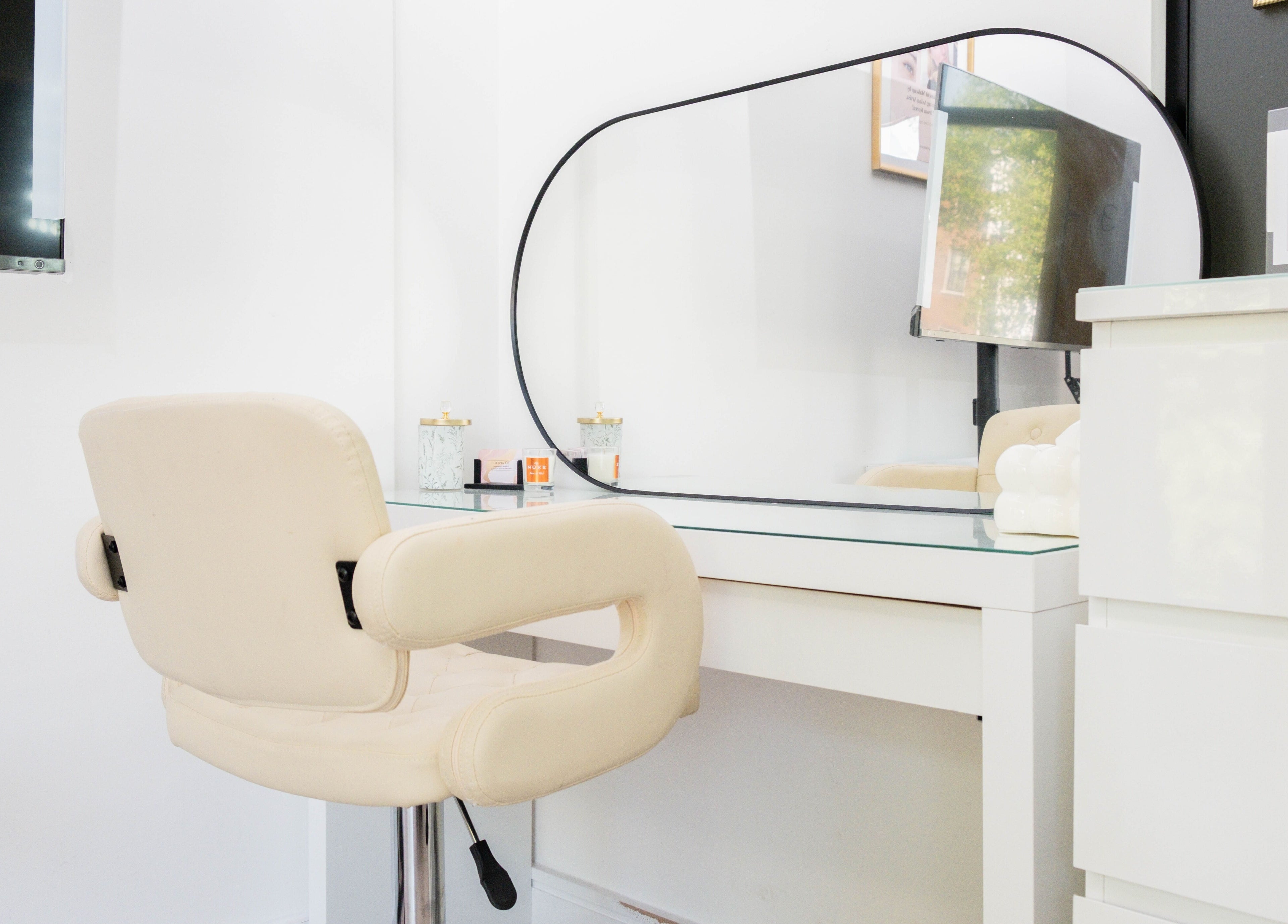 Modern vanity setup at Unique Brow London, featuring a cream chair and mirror. London, England, GB.