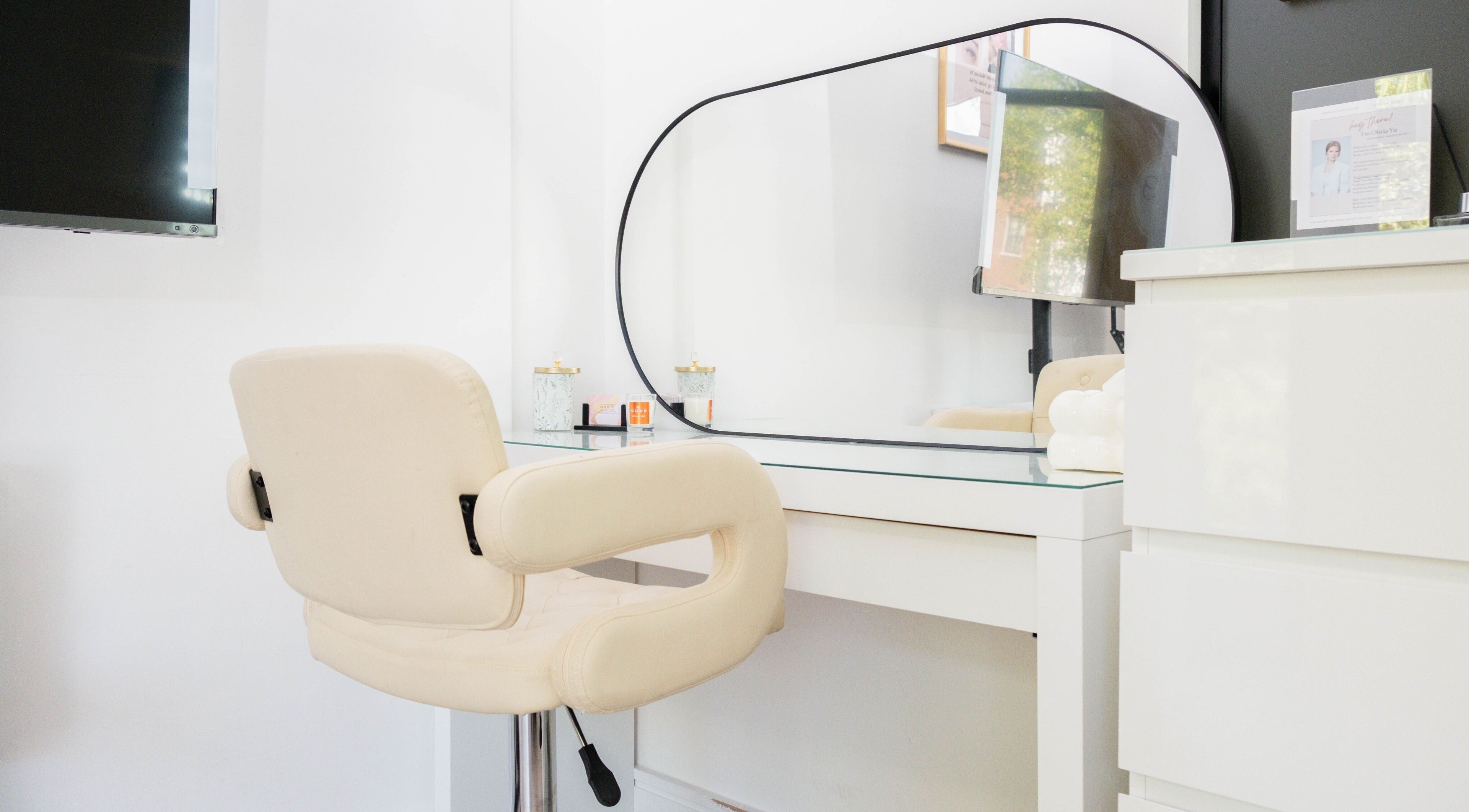 Modern vanity setup at Unique Brow London, featuring a cream chair and mirror. London, England, GB.