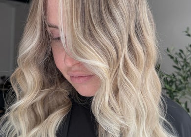 Elegant blonde wavy hairstyle at Coloured by Madison, Plymouth, England, GB.