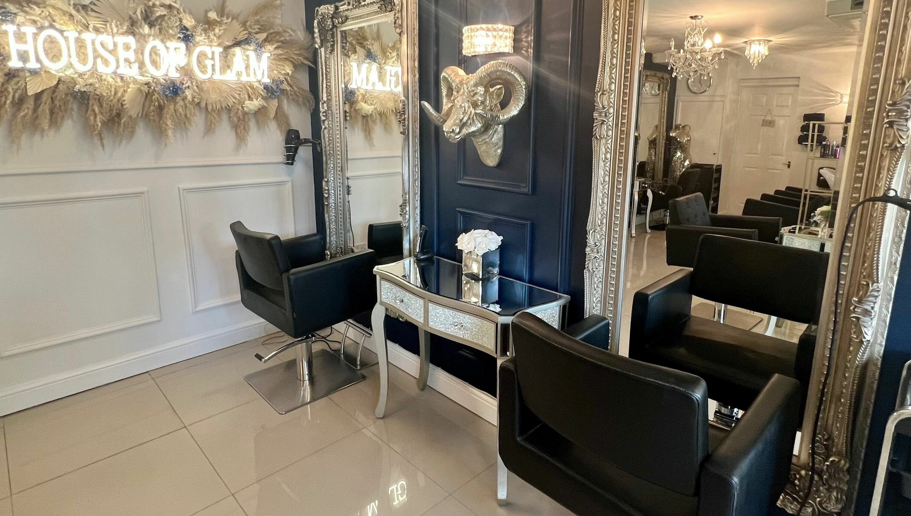 Elegant salon interior at Ludicrous Lengths, Thornbury, England, GB with plush black chairs and ornate mirrors.
