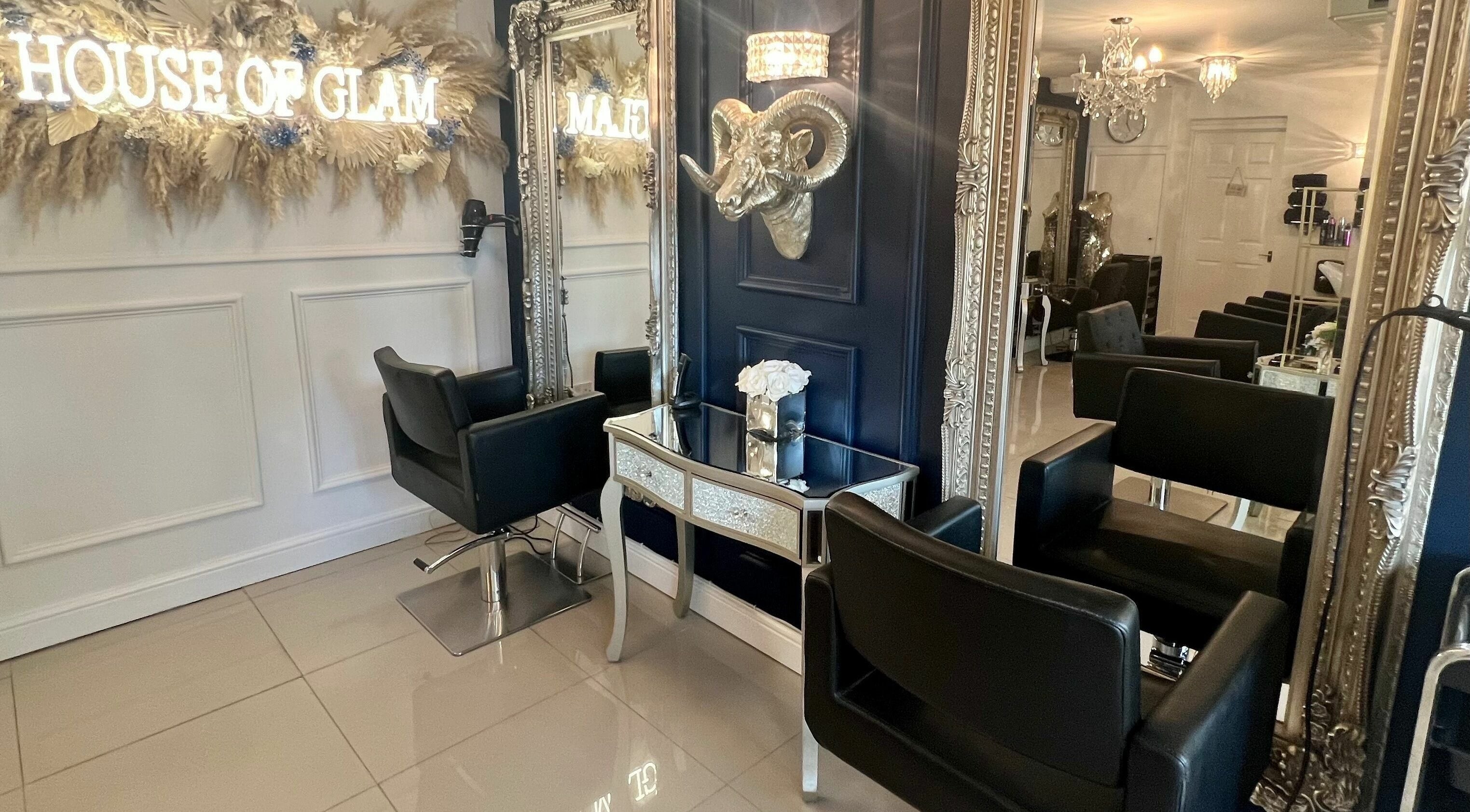 Elegant salon interior at Ludicrous Lengths, Thornbury, England, GB with plush black chairs and ornate mirrors.