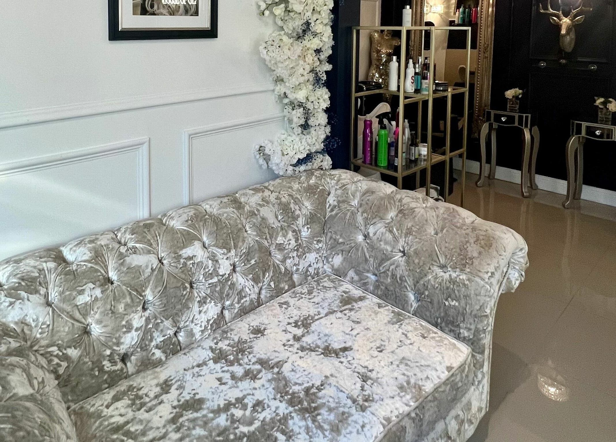 Elegant interior of Ludicrous Lengths, Thornbury, England, GB, showcasing a plush velvet sofa and chic decor.