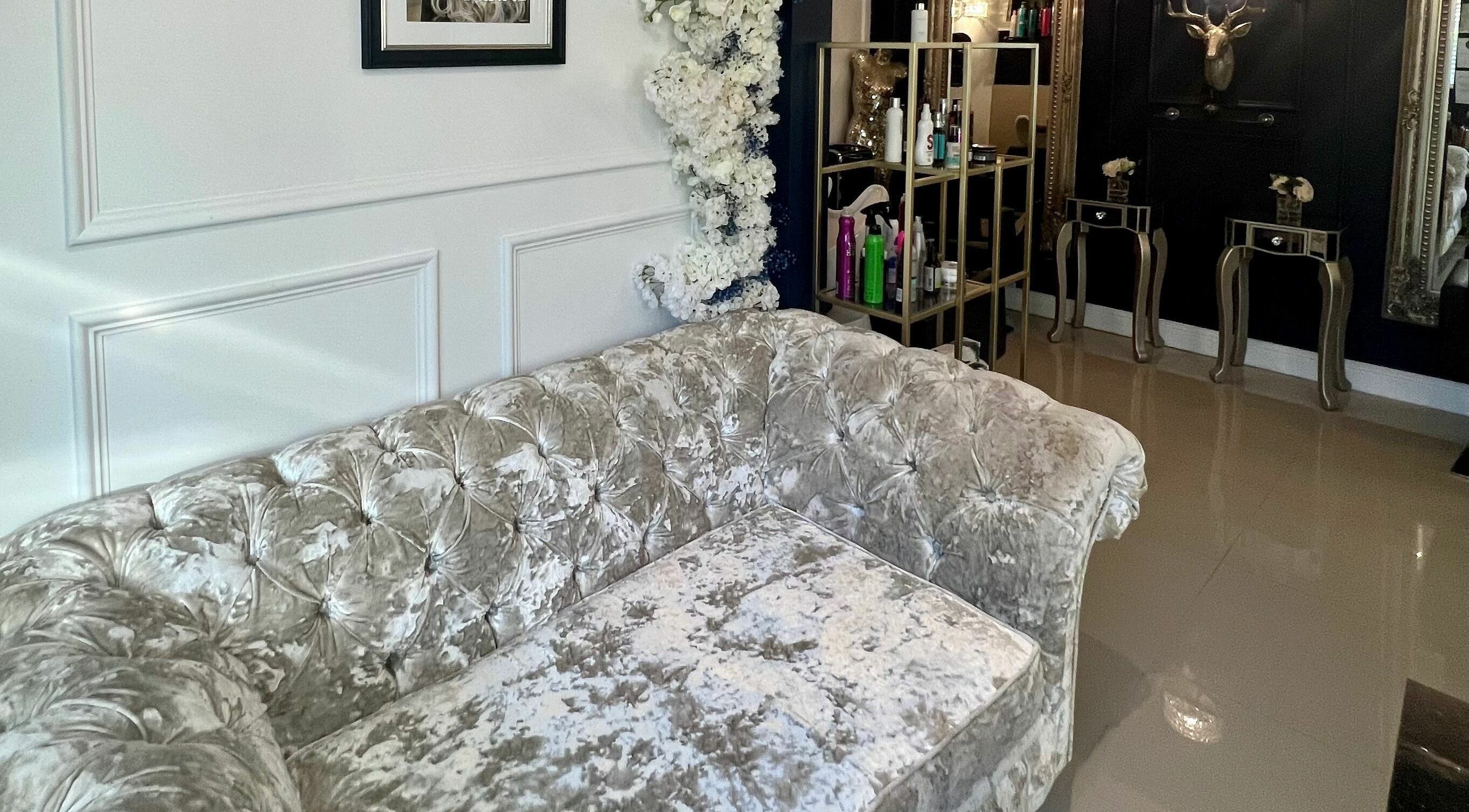 Elegant interior of Ludicrous Lengths, Thornbury, England, GB, showcasing a plush velvet sofa and chic decor.