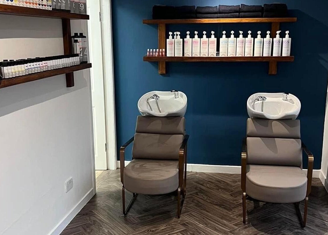 Modern wash station at Hair by Olivia Bain, Kirkintilloch, Scotland, GB. Sleek chairs and product display.