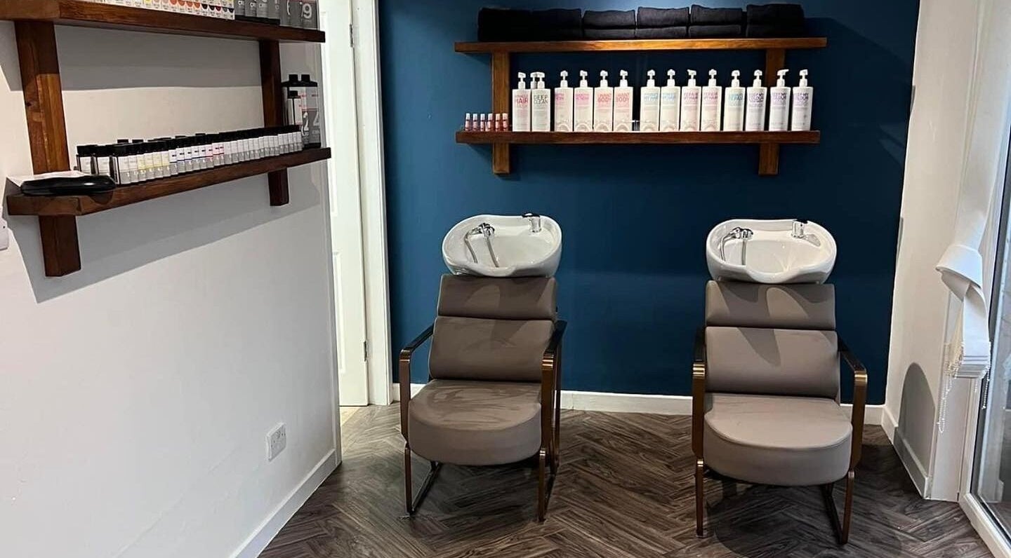 Modern wash station at Hair by Olivia Bain, Kirkintilloch, Scotland, GB. Sleek chairs and product display.