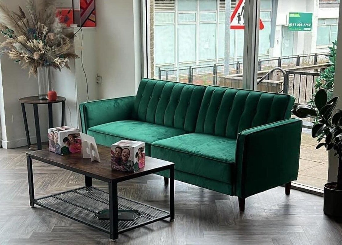 Cozy green sofa in Hair by Olivia Bain's elegant Kirkintilloch salon, Scotland, GB.