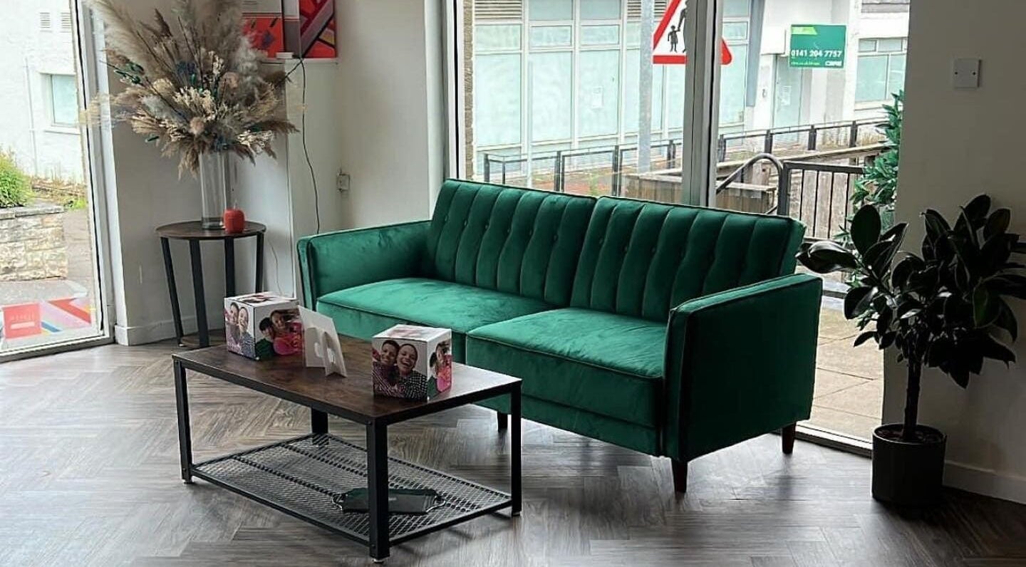 Cozy green sofa in Hair by Olivia Bain's elegant Kirkintilloch salon, Scotland, GB.