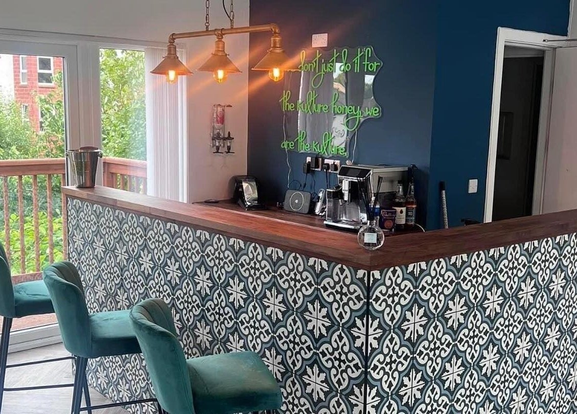 Trendy salon bar at Hair by Olivia Bain, Kirkintilloch, Scotland featuring teal chairs and stylish decor.