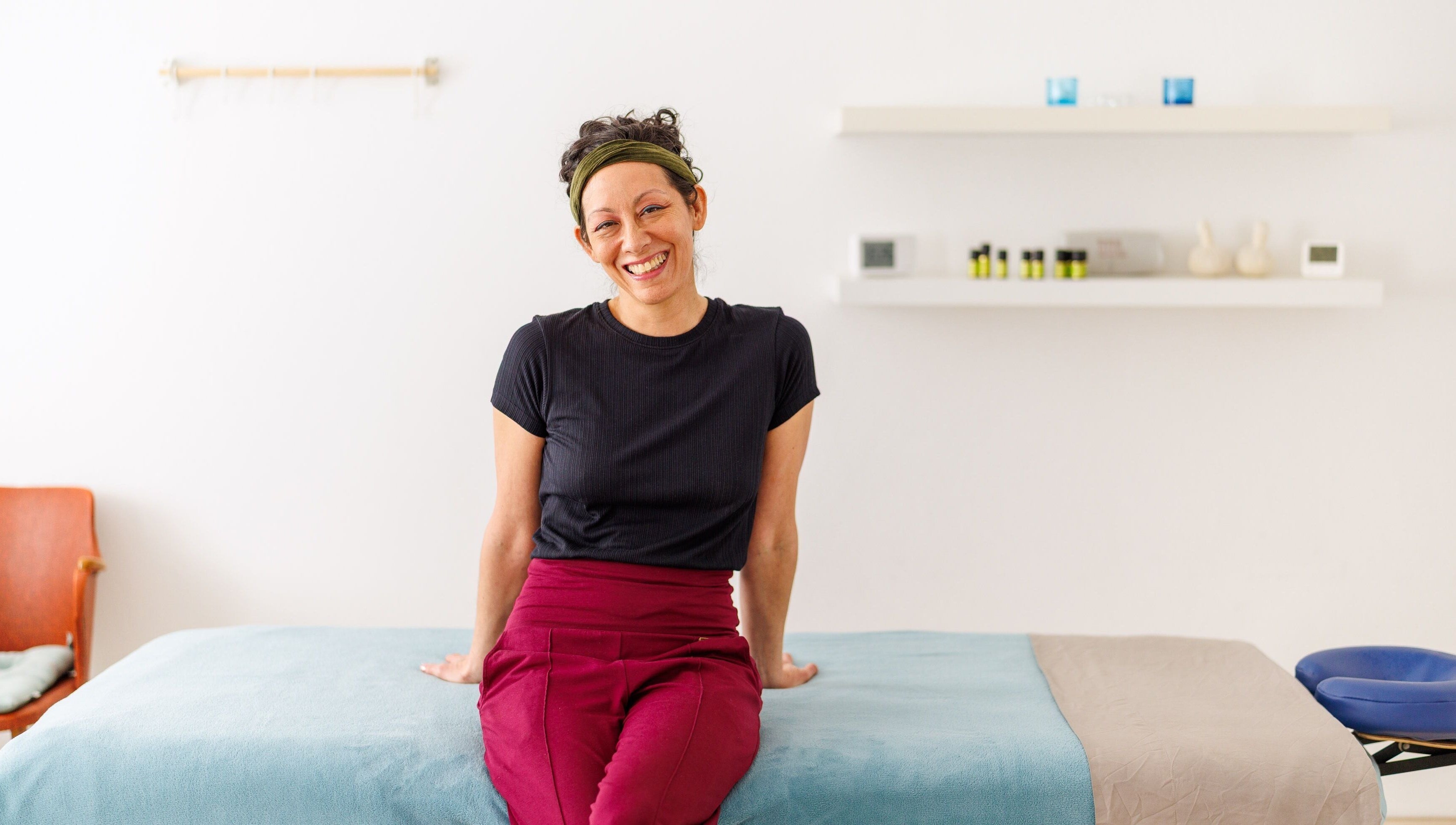 Therapist at Hirai Healing East at HAVEN, Berlin, Berlin, DE, smiling in a tranquil treatment room.