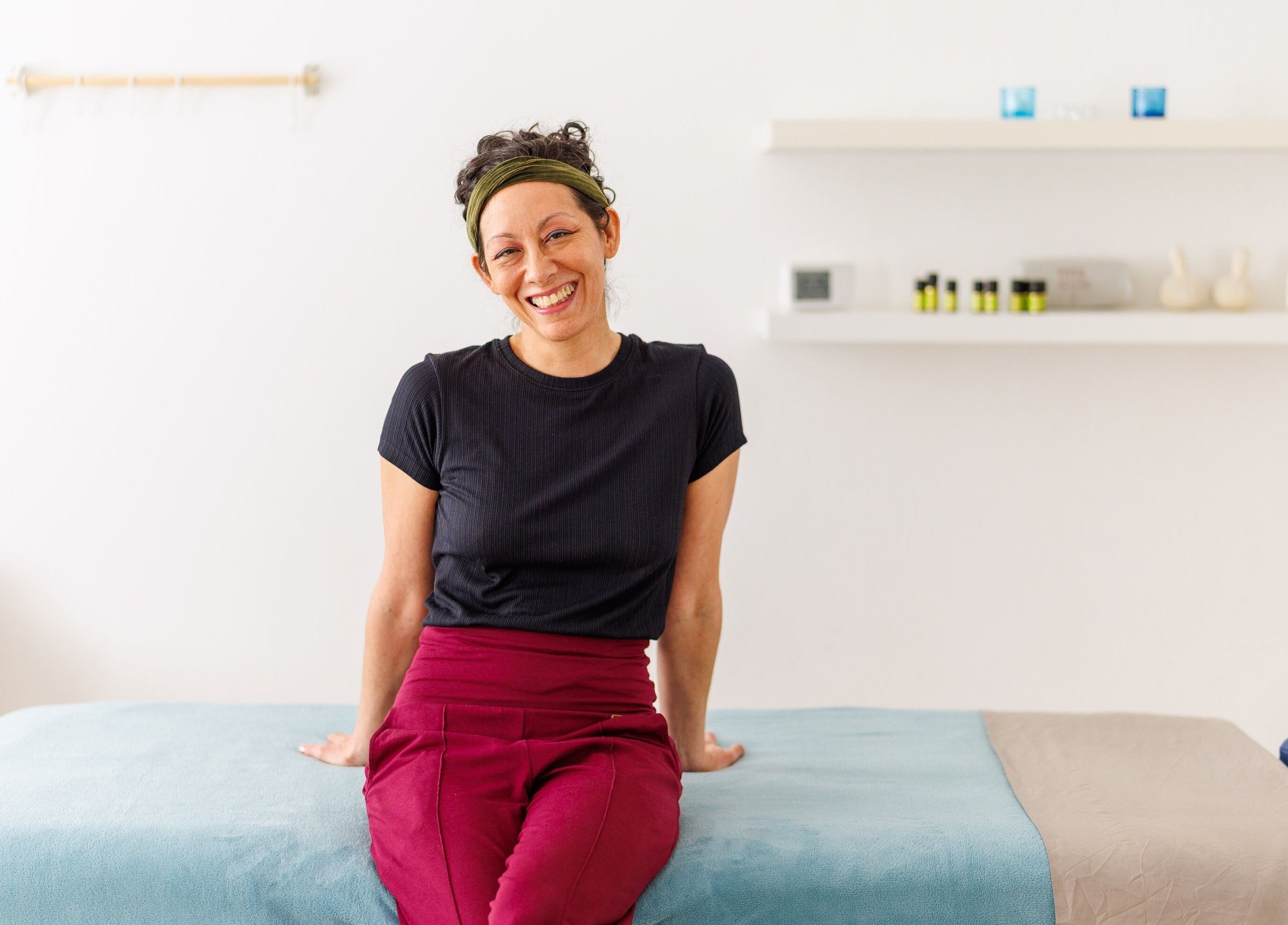 Therapist at Hirai Healing East at HAVEN, Berlin, Berlin, DE, smiling in a tranquil treatment room.