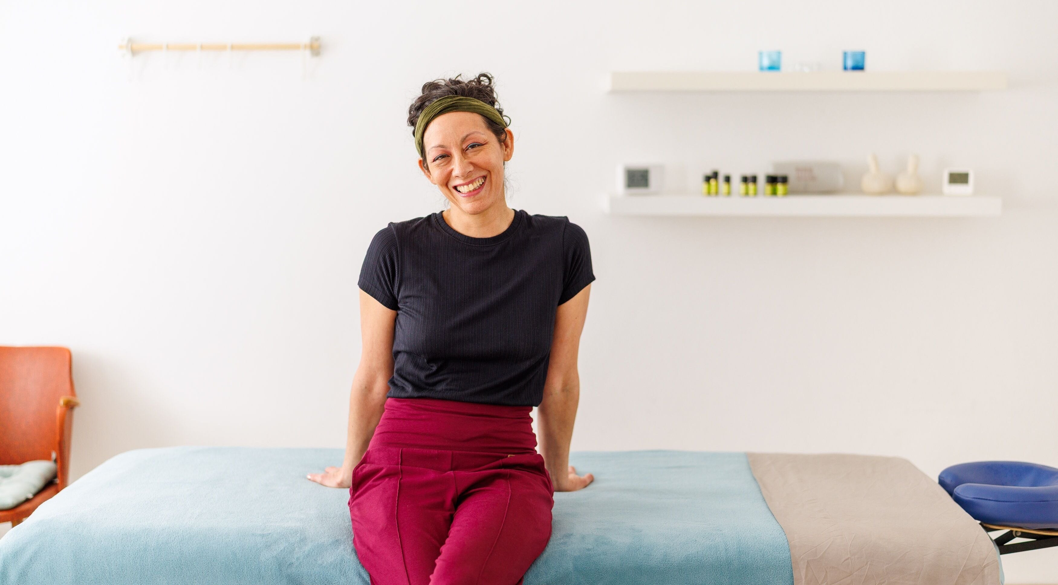 Therapist at Hirai Healing East at HAVEN, Berlin, Berlin, DE, smiling in a tranquil treatment room.
