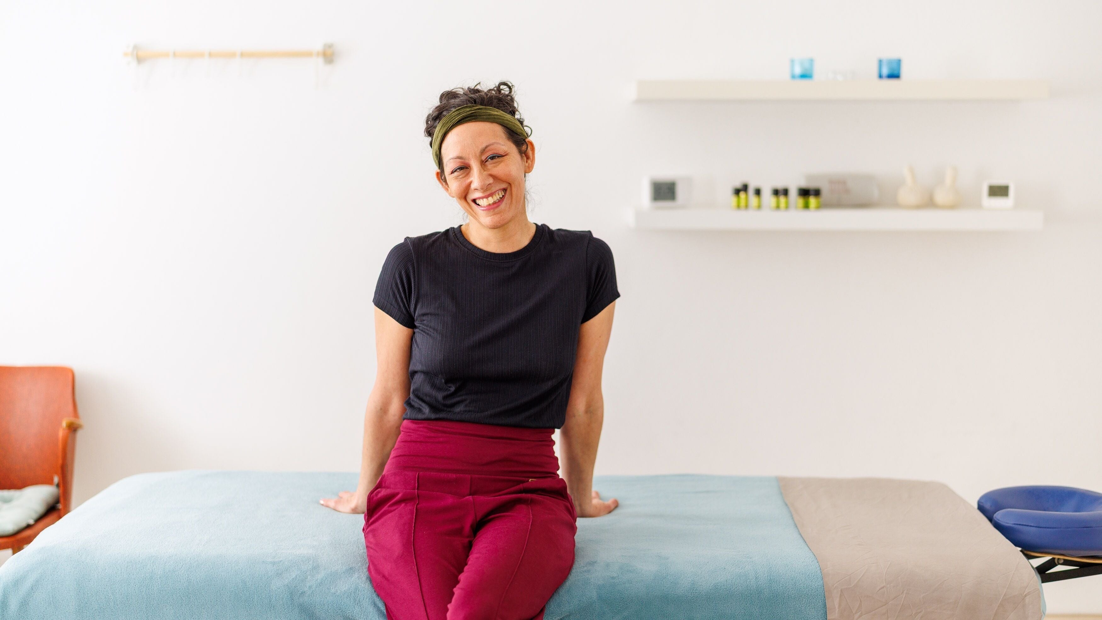 Therapist at Hirai Healing East at HAVEN, Berlin, Berlin, DE, smiling in a tranquil treatment room.