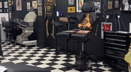 Tattoo studio chair at G’lamore Ink & Beauty, Birmingham, England, GB with artworks on the wall.