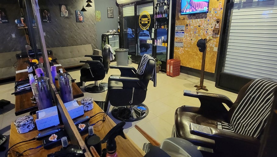 Interior moderno de Peluquería Sergio Rivera en Maravatio, Michoacán, MX con sillas de barbero y decoración estilizada.