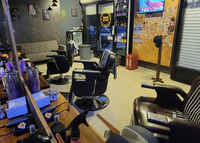 Interior moderno de Peluquería Sergio Rivera en Maravatio, Michoacán, MX con sillas de barbero y decoración estilizada.