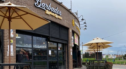Entrada de Barbados Barber Premium en Soacha, Cundinamarca con sombrillas al aire libre.