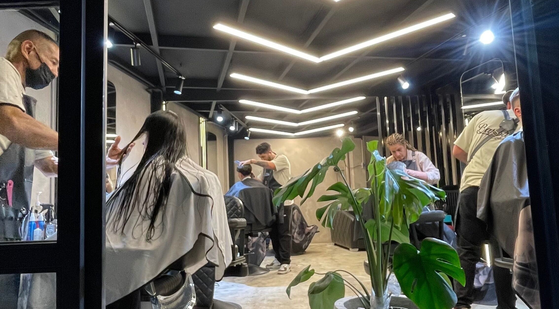 Interior moderno de Barbados Barber Premium en Soacha, Cundinamarca, CO, mostrando clientes en proceso de corte.