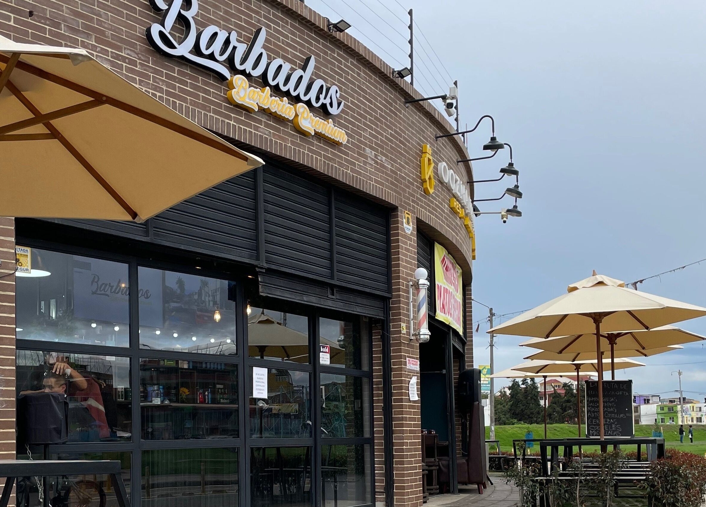 Entrada de Barbados Barber Premium en Soacha, Cundinamarca, CO con sombrillas al aire libre.