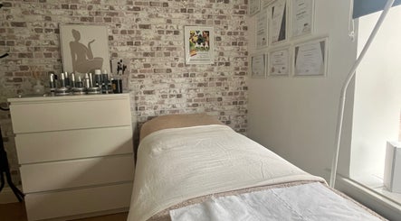 Cozy treatment room at Baileys Beauty Boutique, Newport Pagnell, England, GB. Features bed, decor, and certificates.