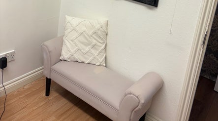 Elegant seating area at Baileys Beauty Boutique, Newport Pagnell, England, GB, featuring a plush cushion.