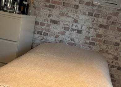Relaxing treatment room at Baileys Beauty Boutique, Newport Pagnell, England, GB with a cozy bed and modern decor.