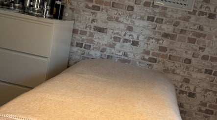 Relaxing treatment room at Baileys Beauty Boutique, Newport Pagnell, England, GB with a cozy bed and modern decor.