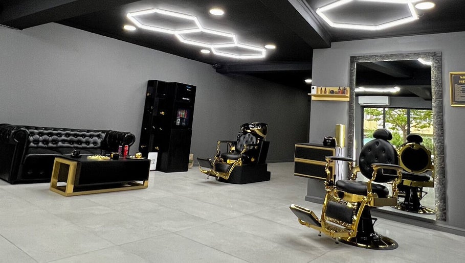 Interior modern la The Godfather Barbershop, București, București, RO, cu scaune de aur și mobilier elegant.