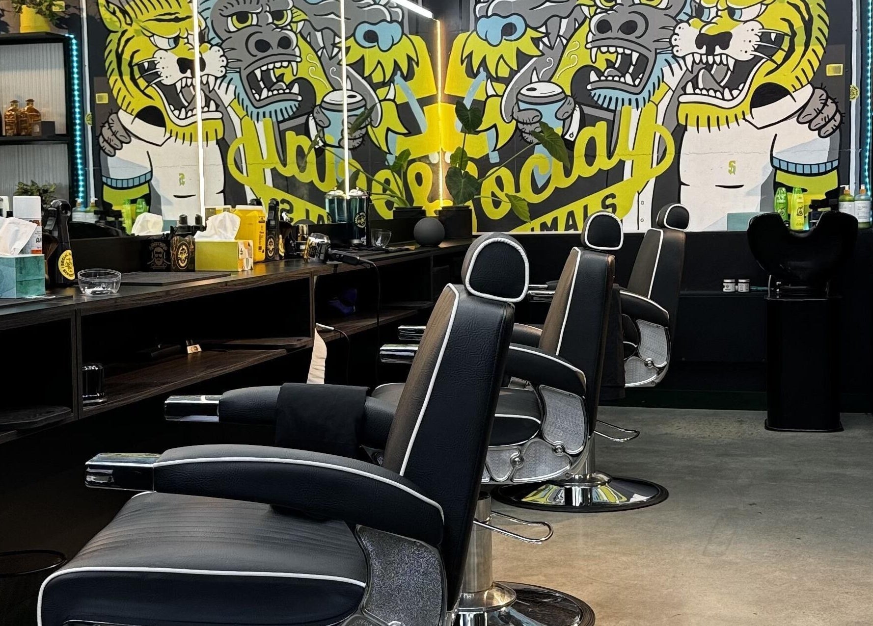 Interior of Social Animals Barbershops in Melbourne, Victoria, AU with artistic mural and modern chairs.